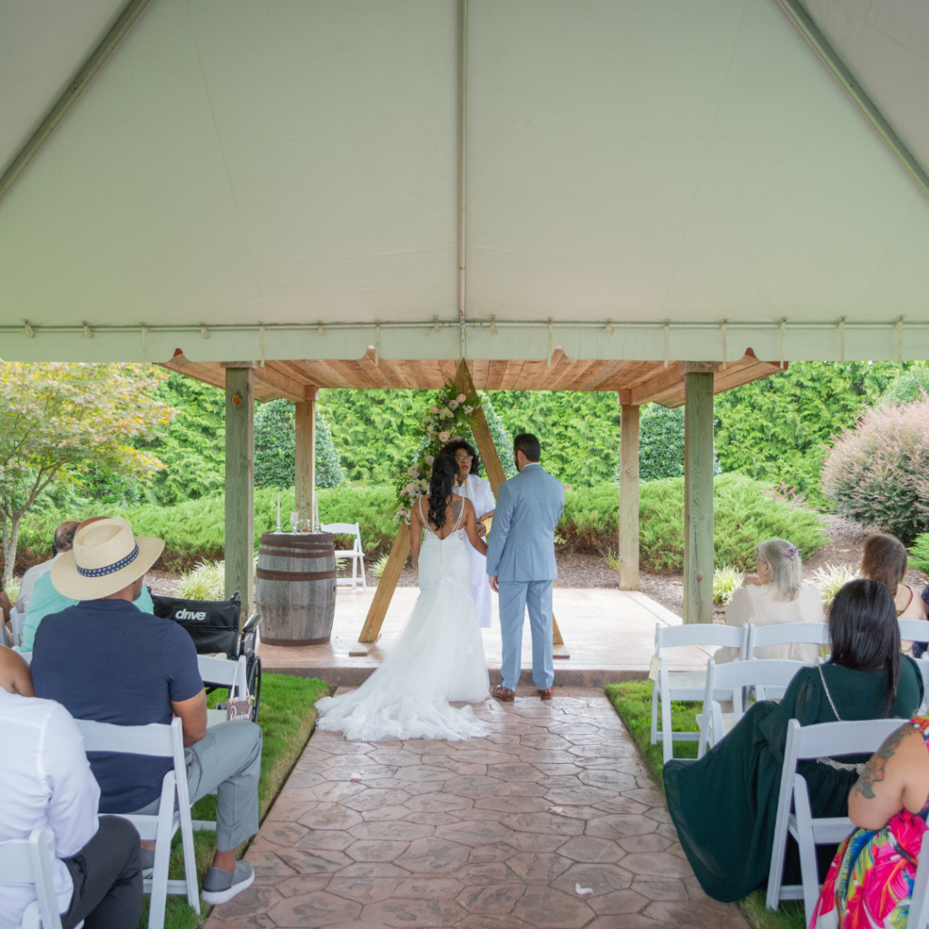 A couple getting married within a frame tent